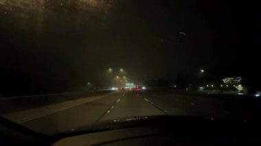 POV bakış açısı, gece şehrinde son derece sisli bir ortamda araba sürmek. Yüksek kalite 4k görüntü