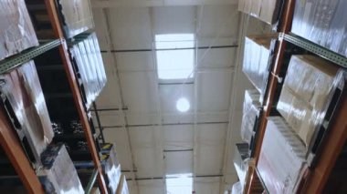 Üretim fabrikasının ticaret deposunda yüksek raflarda depolanmış kutular. Geniş açı. Yüksek kalite 4k görüntü