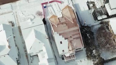Kışın karla kaplı inşaat halindeki evlerin, çerçevelerin ve temellerinin havadan geniş bir görüntüsü. Yüksek kalite 4k görüntü