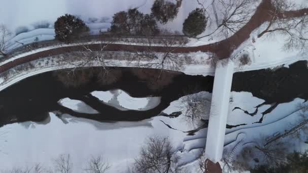 Αεροφωτογραφία Ενός Χειμερινού Ποταμού Γέφυρα Είναι Καλυμμένη Χιόνι Υψηλής Ποιότητας — Αρχείο Βίντεο