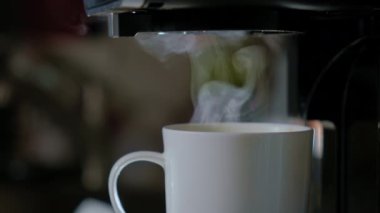 Beyaz bardaktan çıkan sıcak bir içecekten Buhar 'ın yakın görüntüsü. Evin mutfağında yeni bir kafe. Yüksek kalite 4k görüntü