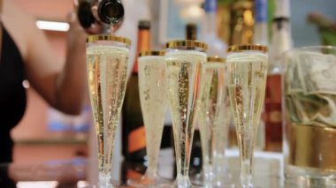 Şampanya bardakları şampanya ve baloncuklarla dolu bir masada. Manzarayı kapat. Yüksek kalite 4k görüntü