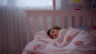 Child little girl sleeps sweetly in his bed. . High quality 4k footage