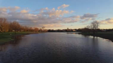 Göl kenarındaki evlere gidip güzel bahar günbatımını seyredelim. Geniş açı. Yüksek kalite 4k görüntü