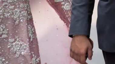 Geleneksel Hint kıyafetleri giyip el ele tutuşan bir çift, Hindu düğünü. Görüntüyü kapat, kamerayı hareket ettir. Yüksek kalite 4k görüntü