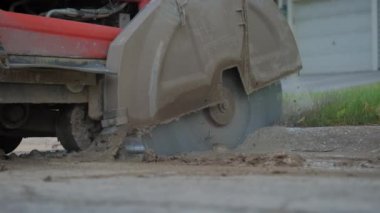 Kesme testeresinin asfalt üzerindeki bir yol yüzeyini onarmak için çekilmiş görüntülerini kapatın. Yavaş çekim. Yüksek kalite 4k görüntü