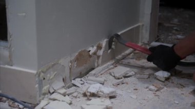 Odadaki bir duvarın yıkılması. Duvardan fayanslar sökülüyor. Evdeki dairenin sökülmesi ve yenilenmesi. Yüksek kalite 4k görüntü