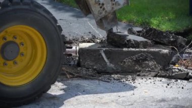 Beton yolda çalışan kazıcı hidrolik kol kırıcının yakın çekimi, hidrolik çekiç tahribatı beton. Yüksek kalite 4k görüntü