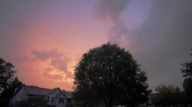 Kenar mahallelerde bir sokak ve fırtınadan sonra akşam vakti renkli bir gökyüzü. Geniş görüş. Yüksek kalite 4k görüntü