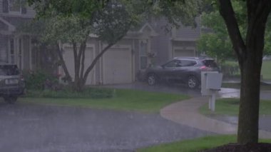 Bir evin önünde arabalı garaj yolu yağıyor. Banliyöde bir sokak. Yüksek kalite 4k görüntü