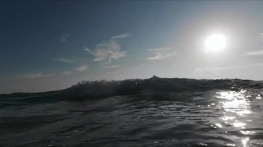 Güneş doğarken okyanus dalgasının yavaş çekim görüntüsü. Geniş çekim. Yüksek kalite 4k görüntü
