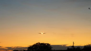 Altın gün batımında Jet Airplane silueti yaklaşıyor. İnişe hazırlanın. Geniş görüş. Yüksek kalite 4k görüntü