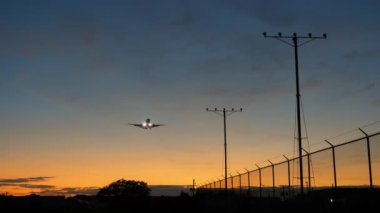 Altın gün batımında Jet Airplane silueti yaklaşıyor. İnişe hazırlanın. - Evet. Yüksek kalite 4k görüntü