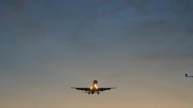 Altın gün batımında Jet Airplane silueti yaklaşıyor. İniş ya da kalkış için hazırlanın. Yüksek kalite 4k görüntü