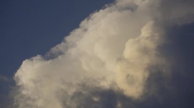 Tüylü fırtına bulutlarının mavi gökyüzü arka planına sahip hareket eden beyaz bulutlar. Yüksek kalite 4k görüntü