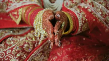 Geleneksel kınalı ellere ve geleneksel Hint kıyafetlerine bürünmüş kırmızı renge yakından bakın. Hindu düğünü unsurları. - Evet. Yüksek kalite 4k görüntü