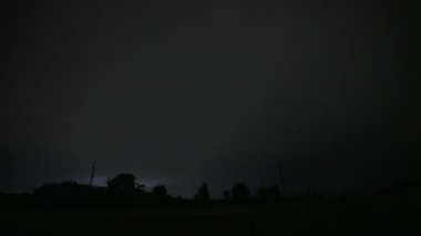 Arazide bir sürü yıldırım ve sürüş arabası var. Şiddetli bir fırtına. Geniş çekim. Yüksek kalite 4k görüntü