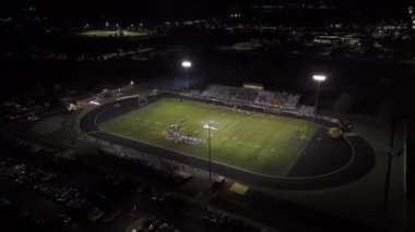 Amerikan futbol takımları gece vakti oyun oynuyor. Geniş Drone görüşü. Yüksek kalite 4k görüntü