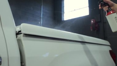 Araba tamircisi araba yüzeyine özel bir sıvı püskürtür. Profesyonel Araç Vücut Detaylı Atölyesi. Yüksek kalite 4k görüntü