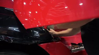 Kapısı açık bir kamyona kazıyıcılı koyu renkli bir PPF filmi uygulamak. Bir arabaya film uygularken çekilen görüntüleri kapat. Yüksek kalite 4k görüntü