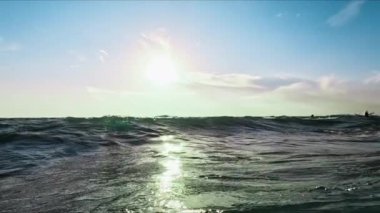 Güneşli ışınlarda okyanus dalgaları. Su kamerayı kapatıyor. Kamera suyun üstünde ve altında. Yüksek kalite 4k görüntü
