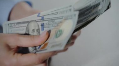 Kadın eli, elinde 100 dolarlık banknotlarla paraları sayıyor. Yüksek kalite 4k görüntü