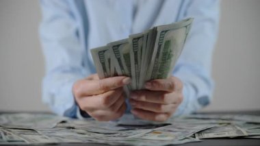 100 dolarlık banknotları tutan kadın elleri. Erkek eli parayı alır. Kapatın. Yüksek kalite 4k görüntü