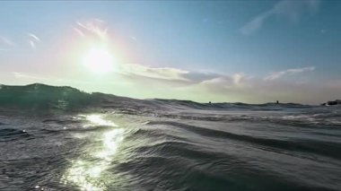 Güneş ışınlarında okyanus dalgaları. Kamera suyun üstünde ve altında. Yüksek kalite 4k görüntü