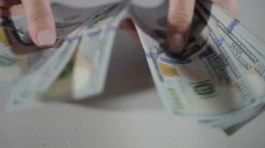 Yüz dolarlık banknotlar tutan kadınların ellerine yakından bakın. Yavaş çekim görüntüsü. Yüksek kalite 4k görüntü