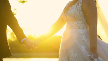 Gelin ve damat düğün günü yürürken el ele tutuşuyorlar. Manzarayı kapat. Yüksek kalite 4k görüntü