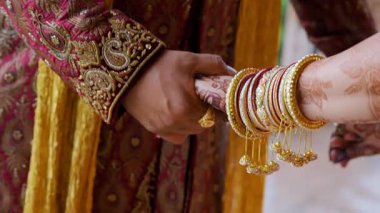 Bir arada duran çift, el ele tutuşuyorlar, geleneksel Hint kıyafetleri giyiyorlar, Hindu düğünü unsurları. Manzarayı kapat. Yüksek kalite 4k görüntü