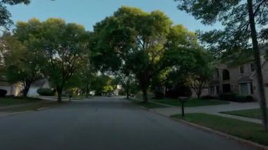 POV, güneşli bir günde ABD 'nin yerleşim bölgesindeki bir banliyö caddesini yakalıyor. Hareket halindeki arabada vurulmuş. Yüksek kalite 4k görüntü