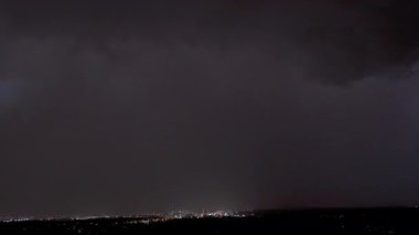 Karanlık fırtına bulutları şehrin üzerinde yanıp sönen yıldırımlarla dolanıyor. Yüksek kalite 4k görüntü