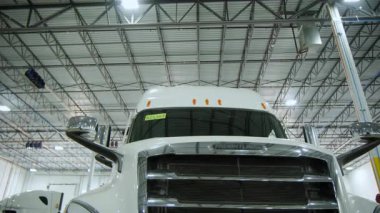 Tamirhanedeki beyaz kamyon, çeşitli cihazlar ve tamirhanedeki kamyonet. Yakın çekim görüntüsü. Ön cam ve ızgara manzarası. Yüksek kalite 4k görüntü