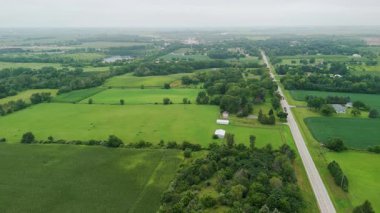 Yalnız yolun ve büyük şehrin yakınındaki güzel yeşil banliyölerin Arial insansız hava aracı manzarası. Geniş hava manzaralı. - Evet. Yüksek kalite 4k görüntü