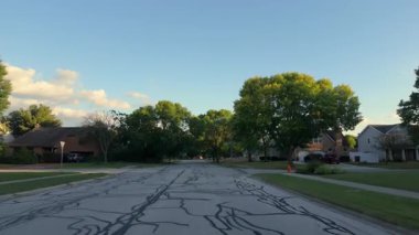 Geniş bir görüntü, güzel güneşli bir günde, hareket halindeki bir arabadan çekilen bir Amerikan mahallesindeki bir banliyö caddesini çekiyor. Yüksek kalite 4k görüntü