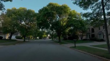 POV, güneşli bir günde ABD 'nin yerleşim bölgesindeki bir banliyö caddesini yakalıyor. Hareket halindeki arabada vurulmuş. Yüksek kalite 4k görüntü