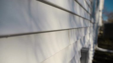 Beyaz kaplamalı ev duvarı, temiz, modern paneller, parlak ve klasik bir dış görünüş sağlıyor. Manzarayı kapat. Yüksek kalite 4k görüntü