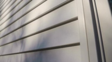 Beyaz kaplamalı ev duvarı, temiz, modern paneller, parlak ve klasik bir dış görünüş sağlıyor. Yüksek kalite 4k görüntü