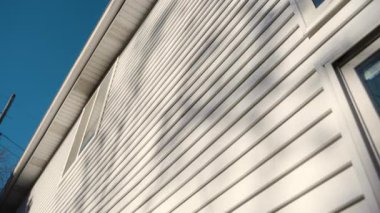 Beyaz kaplamalı ev duvarı, temiz, modern paneller, parlak ve klasik bir dış görünüş sağlıyor. Geniş görüş. Yüksek kalite 4k görüntü