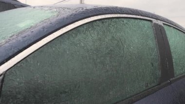 Soğuk bir kış gününde buzla kaplı donmuş araba camları sert hava koşullarını ve mevsimsel zorlukları vurguluyor. Yüksek kalite 4k görüntü