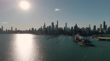 Şehir merkezindeki Chicago şehrinin gökdelenli modern şehir manzarası. Sahnede sakin mavi sulara demirlenmiş teknelerle dolu bir marina yer alıyor. Sonbahar sezonu. 4k görüntü