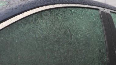 Soğuk bir kış gününde buzla kaplı donmuş araba camları sert hava koşullarını vurguluyor. Yüksek kalite 4k görüntü