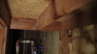 Bodrumdaki ahşap duvar çivileri ya da inşaat alanı arasına yerleştirilmiş sarı fiberglas yalıtım malzemesi. - Evet. Yüksek kalite 4k görüntü