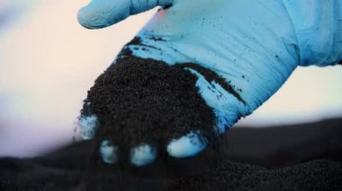 Lastik geri dönüşüm tesisinde öğütülmüş plastik granülleri döken bir işçi. Yüksek kalite 4k görüntü