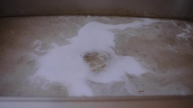 Paslanmaz çelik lavabo bulanık, kahverengi su, drenaj sorunu, tıkanmış borular ya da kirlenmiş su kaynağıyla dolu. Kirli su lavaboya geri geliyor. Yüksek kalite 4k görüntü