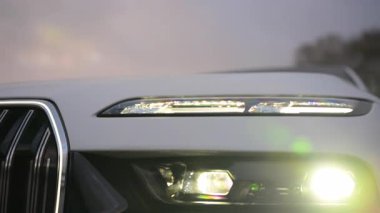 BMW 7 'nin beyaz arabasının farları. Naperville IL.USA 5 Ekim 2024. Yüksek kalite 4k görüntü