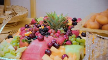 Meyve, böğürtlen, ananas, karpuz, muz, kavun ve üzüm çeşitleri mekândaki kutlama partisinde. Yüksek kalite 4k görüntü