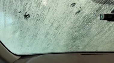 Otomatik oto yıkama sisteminden geçen bir arabanın içinden geniş çaplı görüntüler. Ön manzara. Yüksek kalite 4k görüntü
