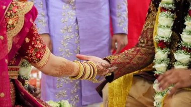 Kutsal düğün töreninde gerçekleştirilen Hint Hindu ayinleri. Gelin ve damat el ele tutuşuyorlar. Düğün töreninin bir kısmını yakından çek. Yüksek kalite 4k görüntü